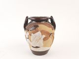 a brown vase with a flower on it on a white surface