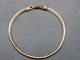 a gold bracelet with a braid design on it