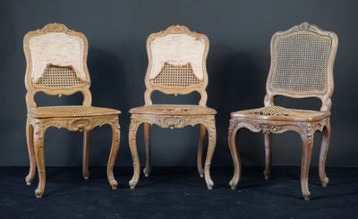 trois chaises avec un dossier en rotin, posées les unes contre les autres sur un fond noir