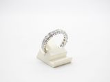 une bague en or blanc et diamants posée sur un socle en marbre
