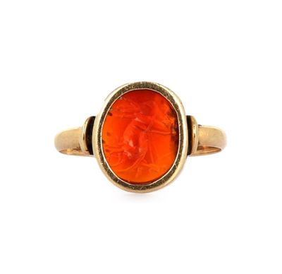 un gros plan d'une bague en or ornée d'une pierre orange au centre