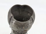 a silver vase with a flower on it on a table