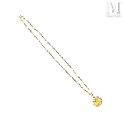 a gold necklace with a coin on a chain