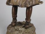 bronze statue of a young girl holding a basket of flowers