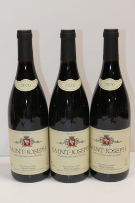 trois bouteilles de vin sont alignées sur une surface blanche