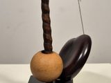 a sculpture of an egg on a stand with a rope