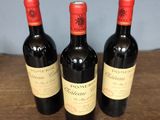three bottles of wine sitting on top of a wooden table