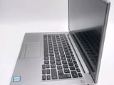 a silver laptop computer sitting on top of a white table