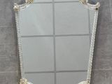 a close up of a mirror hanging on a wall in a bathroom