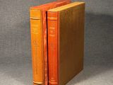 two orange books sitting on top of each other on a table