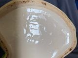a white and green bowl sitting on a blue couch