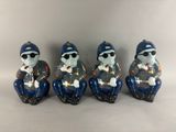 three ceramic figurines of a man with sunglasses and a hat