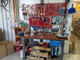 a workbench with tools on it and a stool in front of it