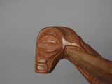 a close up of a wooden walking stick with a face on it