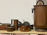 de nombreuses casseroles et poêles rangées sur une étagère dans une pièce