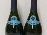 two bottles of champagne sitting next to each other on a table