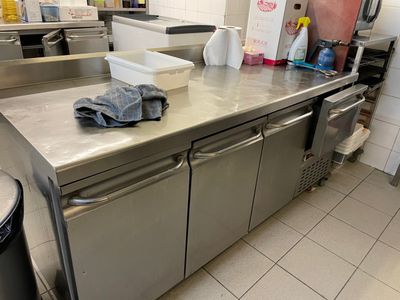 stainless steel counter top in a commercial kitchen with a trash can