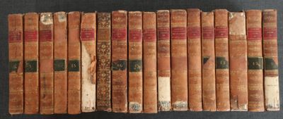 Plusieurs vieux livres sont alignés sur une surface noire