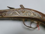 an old gun with a decorative design on the side of it