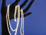 un gros plan sur la main d'une personne tenant un bracelet en perles