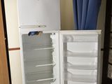 un réfrigérateur blanc et un rideau bleu dans une pièce