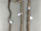 two old canes with tags on them sitting next to each other