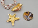 three pieces of jewelry including a starfish, a shell, and a bracelet