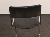 a black chair that is sitting in the corner of a room