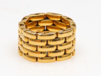 une image d'un gros plan d'une bague en or sur une surface blanche