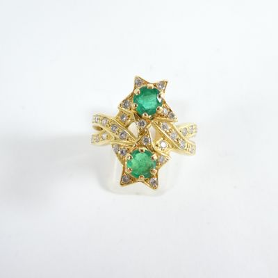 a close up of a gold ring with a green stone and diamonds
