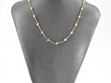 a gold chain necklace on a mannequin display with a white background