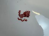a white plate with a red bird on it