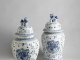 two blue and white vases with lids on a gray background