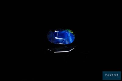 un gros plan d'une pierre bleue et verte sur une surface noire