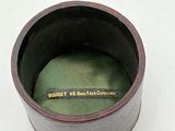 a small black container with a green lid on a white surface