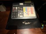 une personne assise à un bureau sur lequel se trouve une calculatrice