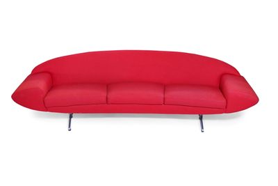 Le canapé rouge est posé sur une surface blanche, avec un fond blanc.