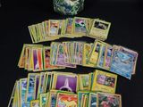 une pile de cartes Pokémon posée sur une table à côté d'un casque