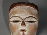 une image représentant un masque en bois sur fond gris