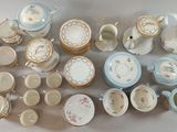 many cups and saucers that are sitting on a table