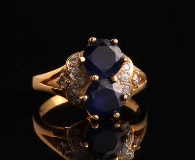 a close up of a gold ring with a sapphire and diamonds