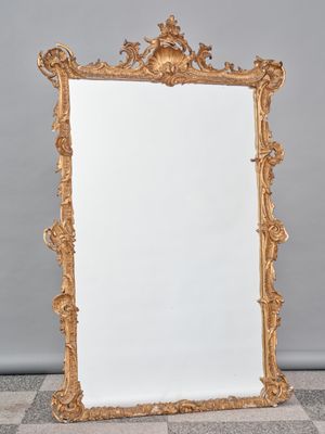 un miroir au cadre doré ouvragé posé sur un sol en damier