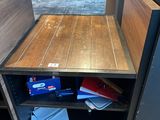 a small table with a book shelf in the corner of the room