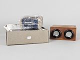 a box with two speakers and a wooden block on the table