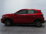 the red suv is parked in a room with a white wall