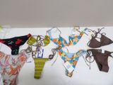 de nombreux modèles de bikinis posés sur une table blanche