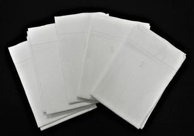 une pile d'enveloppes blanches posée sur une surface noire