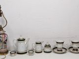 a table with a vase, cups, and a lamp on it
