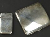 two silver lighters sitting next to each other on a table