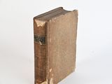 an old book sitting on top of a white table